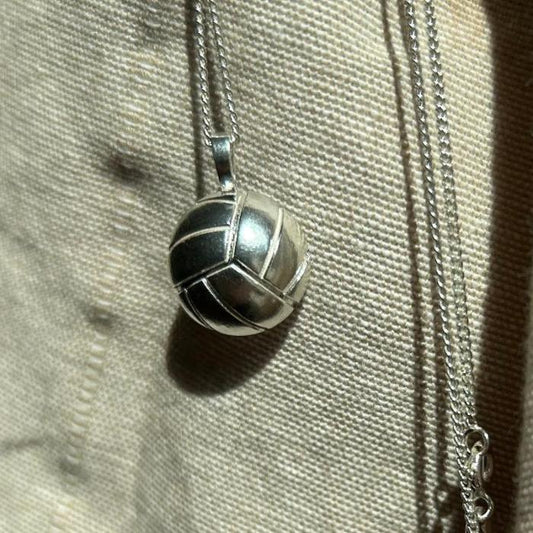 Silberner Volleyballanhänger. Die Nähte des Balls sind in die Halbkugel eingelassen.