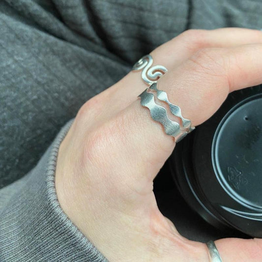 Zu sehen sind der Antiwave Small und Antiwave Big an einem Finger übereinander getragen. Im Hintergrund kann man am anderen Finger noch den Olbia Flow erkennen.