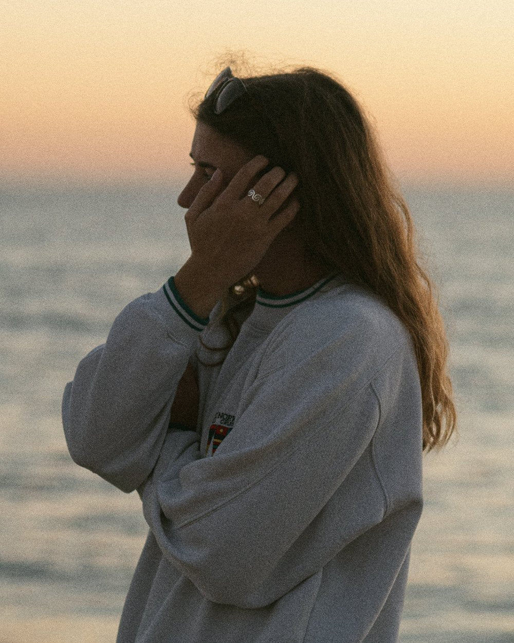 Das Bild zeigt Katrin am Strand mit dem Olbia Flow am Finger. Im Hintergrund sieht man das Meer und den Sonnenaufgang.